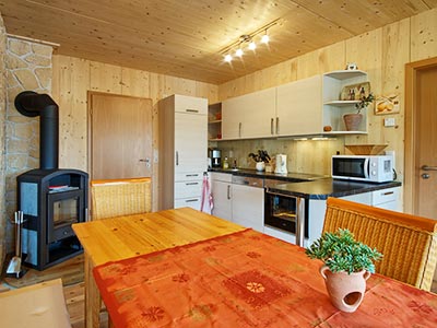 Wohn- und Esszimmer mit Kaminofen und gut ausgestatteter Küche